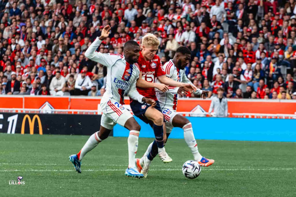 Hakon Haraldsson engagé dans un duel avec deux adversaires pendant LOSC - OL.