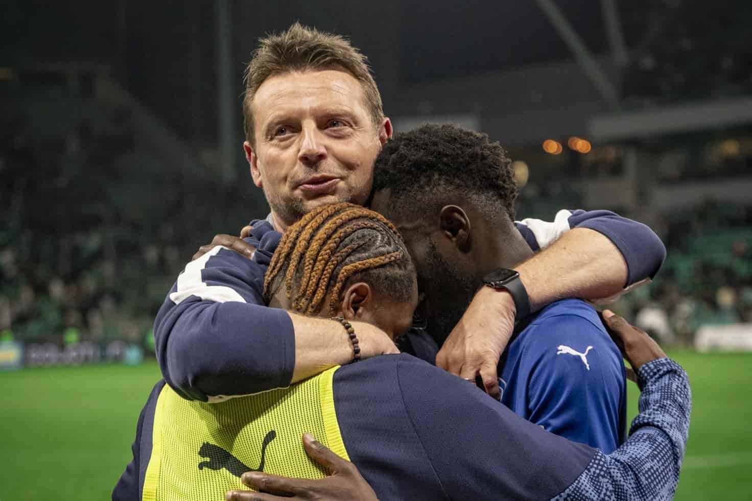 St&eacute;phane Dumont, entra&icirc;neur de l'ESTAC Troyes, enlace ses joueurs, promus en Ligue 1.
