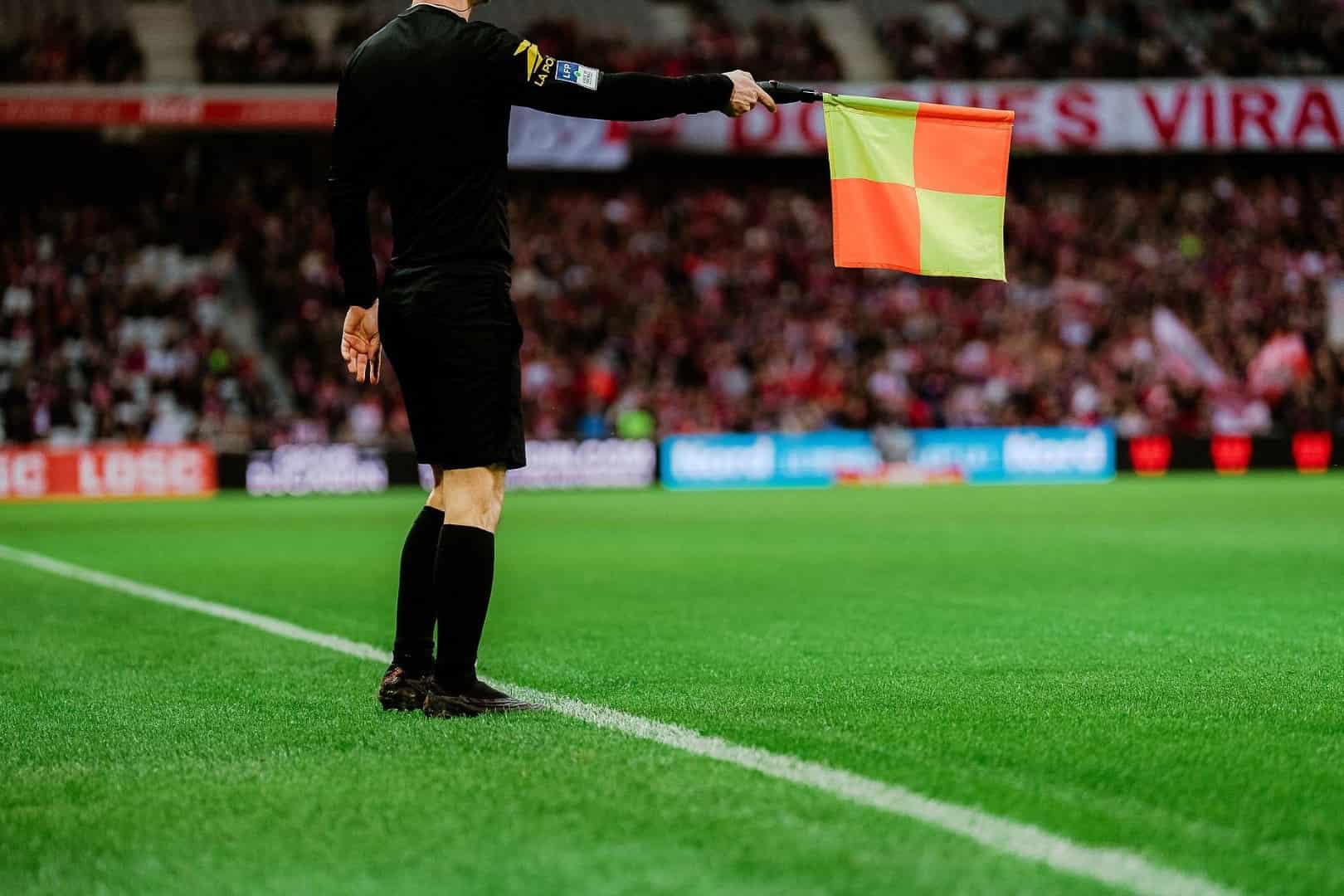 Un arbitre de touche en Ligue 1 signale un hors-jeu.