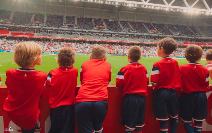 Des jeunes qui regardent l'&eacute;chauffement des Dogues depuis le bord de pelouse.