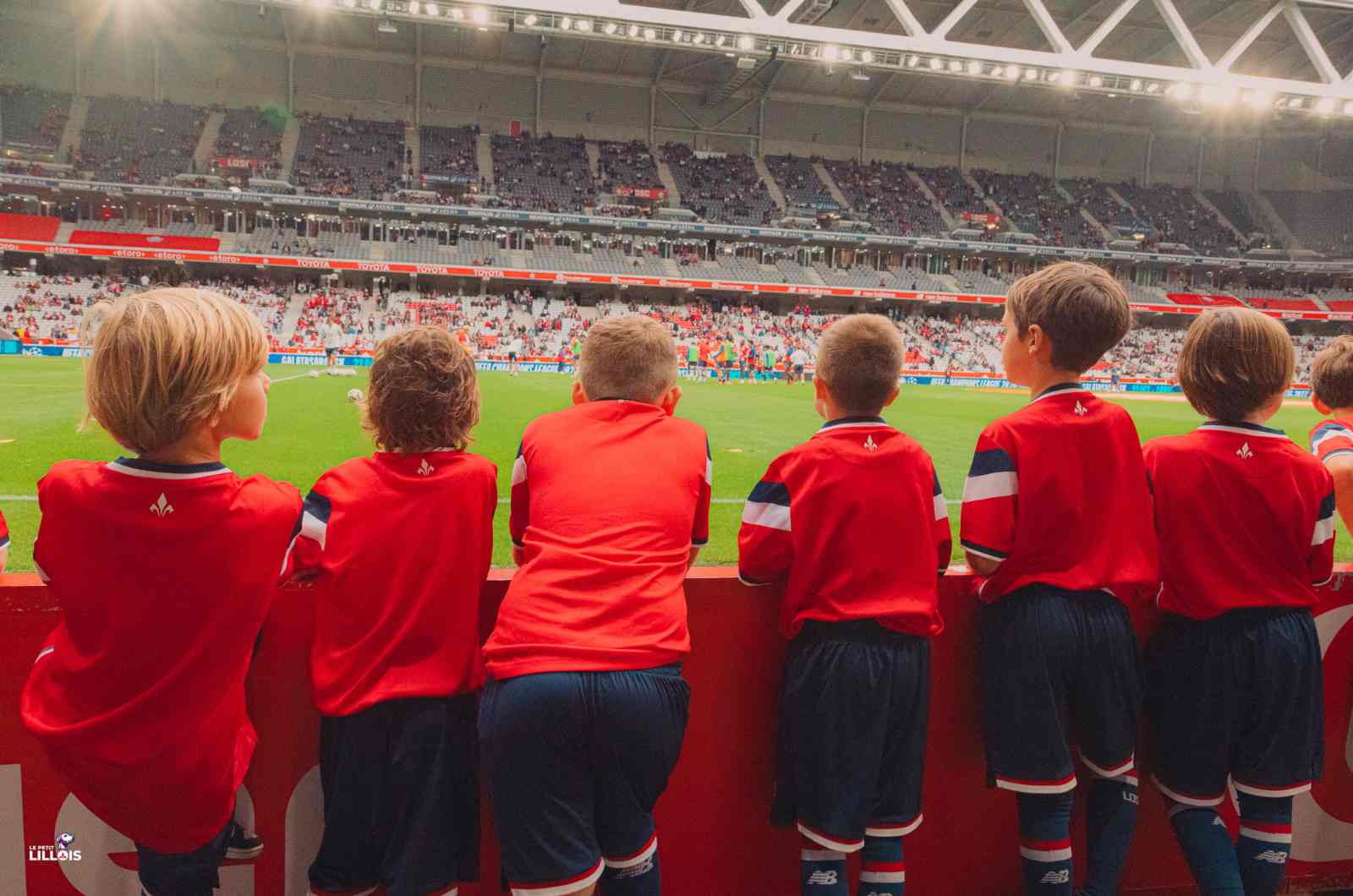 Des jeunes qui regardent l'&eacute;chauffement des Dogues depuis le bord de pelouse.