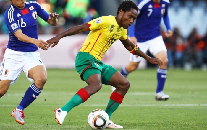 BLOEMFONTEIN, SOUTH AFRICA - JUNE 14: Yoshito Okubo of Japan pressures Jean Makoun of Cameroon during the 2010 FIFA World Cup South Africa Group E match between Japan and Cameroon at the Free State Stadium on June 14, 2010 in Mangaung/Bloemfontein, South Africa.